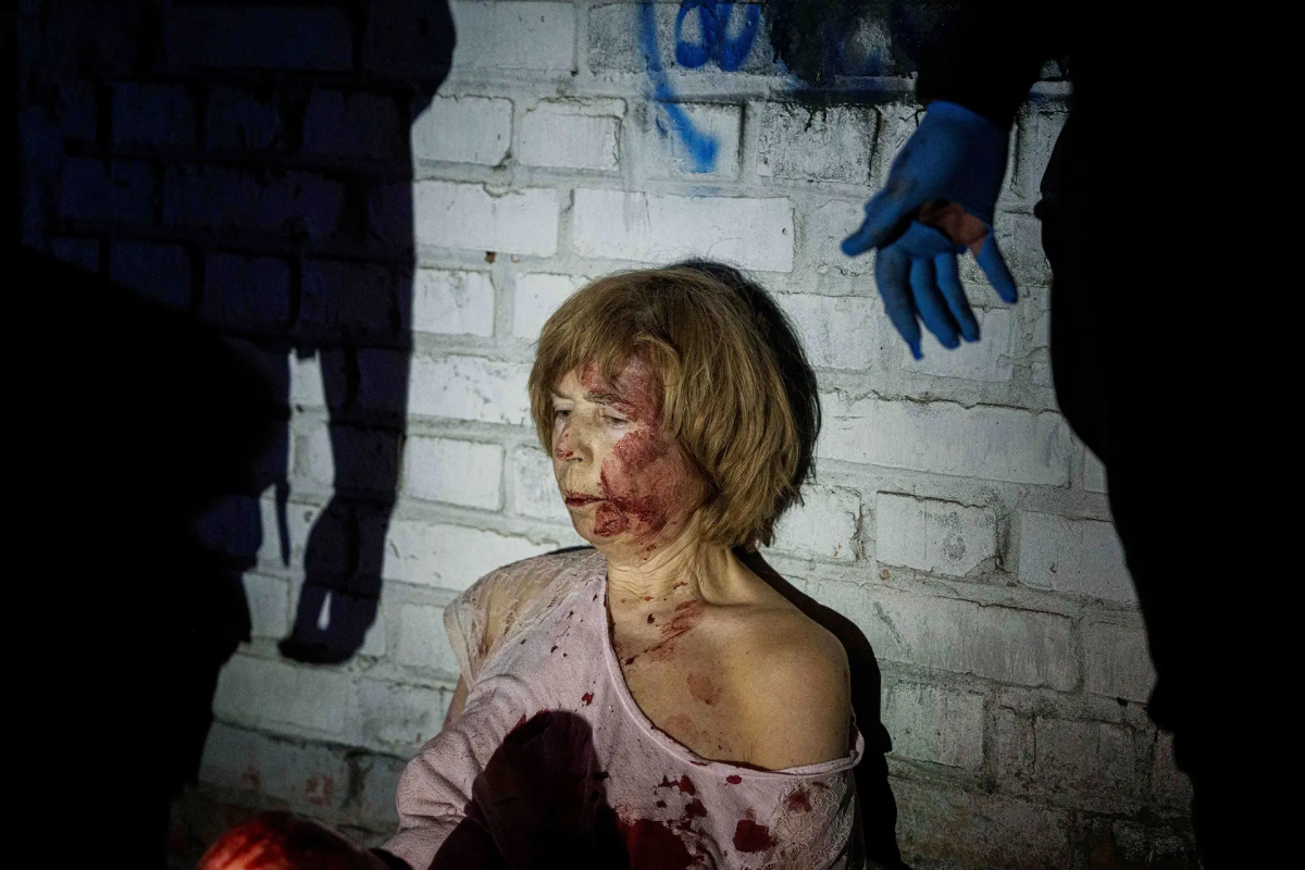 Поранена жінка сидить біля свого будинку, який був пошкоджений російським авіаударом, у житловому районі Києва, Україна, 24 квітня. Євген Малолєтка — AP